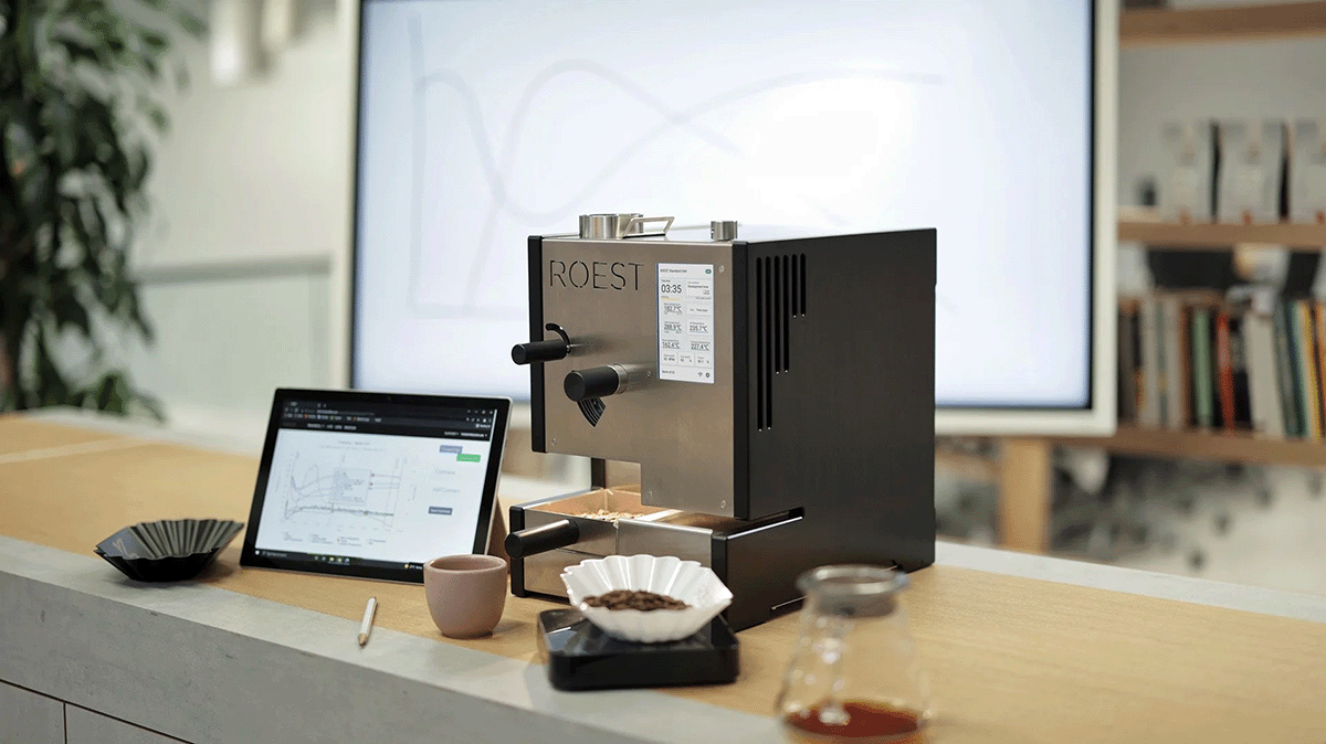 ROEST L200 Plus in the quality control lab next to roasting software on tablet and cupping tray with roasted sample