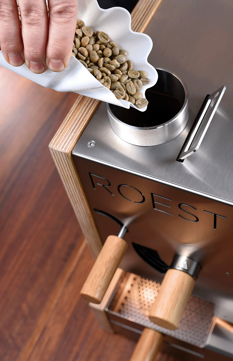 Pouring green coffee beans into ROEST sample roaster to start sample roasting process